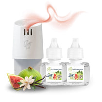 White Scent Fill plug-in diffuser releasing a soft pink fragrance mist beside two Fig & Whipped Vanilla refill bottles, with a sliced fig, vanilla beans, and a white flower on a light background.