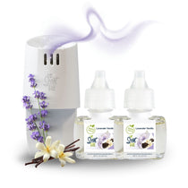 White Scent Fill plug-in diffuser releasing a soft purple fragrance mist beside two Lavender Vanilla refill bottles, with lavender sprigs, vanilla beans, and white flowers on a light background.