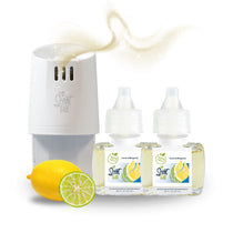 White Scent Fill plug-in diffuser releasing a soft yellow fragrance mist beside two Lemon & Bergamot refill bottles, with a whole lemon and sliced bergamot on a light background.