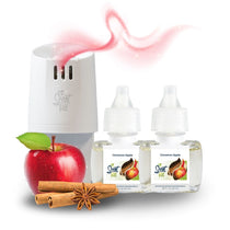 White Scent Fill plug-in diffuser releasing a soft pink fragrance mist beside two Cinnamon Apple refill bottles, with a red apple, cinnamon sticks, and star anise on a light background.