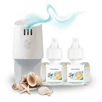 White Scent Fill plug-in diffuser releasing a soft blue fragrance mist beside two Ocean Minerals refill bottles, with seashells and a starfish on a light background.