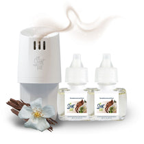 Scent Fill plug-in diffuser with two Sandalwood and Oud refill bottles displayed beside wood pieces and a white flower, with a soft warm scent trail rising above.