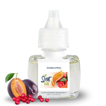 Scent Fill Cranberry Plum plug-in air freshener refill bottle (0.68 fl oz / 20ml) on a white background. The clear bottle with a white diffuser cap displays the Scent Fill logo on its label. Fresh plums — one whole and one halved to reveal its pit — and a cluster of red cranberries are arranged in the foreground to the left of the bottle, representing the product's fragrance notes.