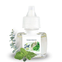Scent Fill Eucalyptus Spearmint plug-in air freshener refill bottle on a white background. The clear bottle with a white diffuser cap displays the Scent Fill logo on its label. A sprig of eucalyptus is arranged to the left of the bottle and fresh spearmint leaves are placed in the foreground, representing the product's fragrance notes.